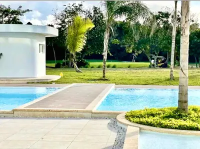 a swimming pool with palm trees in a park at Luxury Apartment With Pool And Golf View in Punta Cana