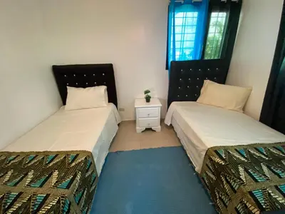 a bedroom with two beds and a night stand at Santiago Center Huge Apartment 2stay rooftop to enjoy the city view 6-3 in Santiago de los Caballeros