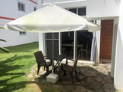 a table and chairs under a white umbrella at Studio Residencial Almendra in Cabarete