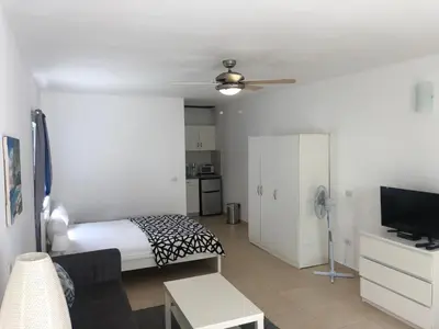 a bedroom with a bed and a flat screen tv at Studio Residencial Almendra in Cabarete