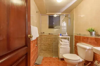 a bathroom with a toilet and a sink and a shower at Escape 3BR Apartment Close to Downtown Mall in Bella Vista in Santo Domingo