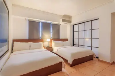 a hotel room with two beds and a window at Escape 3BR Apartment Close to Downtown Mall in Bella Vista in Santo Domingo
