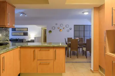 a kitchen with a table and a dining room at Escape 3BR Apartment Close to Downtown Mall in Bella Vista in Santo Domingo
