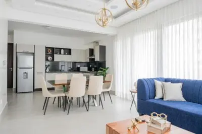 a living room with a blue couch and a table at Luxurious and Spacious Condo in Santiago de los Caballeros
