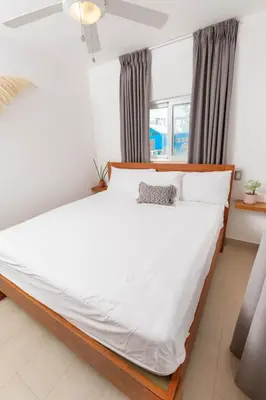 a bedroom with a large bed with white sheets at Amazing Ocean Front - 2 bedroom Apartment (117 sq meters) in Cabarete