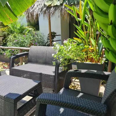 a patio with two chairs and tables and bananas at BUNGALOWS COLIBRI in Las Galeras