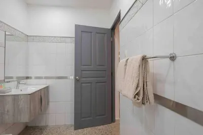 a bathroom with a sink and a door to a shower at Escape 2BR Apartment in Gazcue Close to Colonial Zone in Santo Domingo