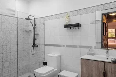 a bathroom with a toilet and a sink and a shower at Escape 2BR Apartment in Gazcue Close to Colonial Zone in Santo Domingo