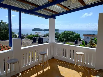 a balcony with stools and a view of the ocean at Apart cercano al muelle y al malecón de Samana in Santa Bárbara de Samaná