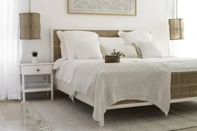 a bedroom with a bed with white sheets and a table at New Beachfront Penthouse Punta Popy in Las Terrenas