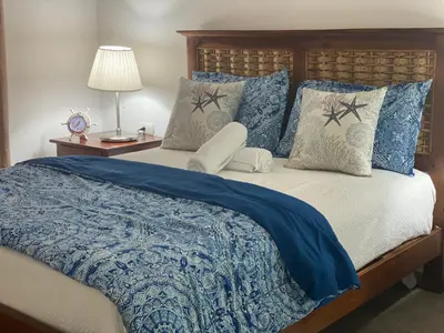 a bedroom with a bed with blue comforter and pillows at Espectacular BZII, bayahibe in Bayahibe