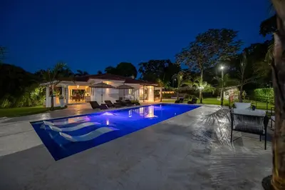 a swimming pool in front of a house at night at Luxury 4-Bedroom Villa with Climate Pool in Sosúa
