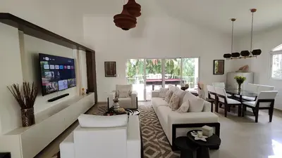 a living room with a white couch and a table at Luxury 4-Bedroom Villa with Climate Pool in Sosúa