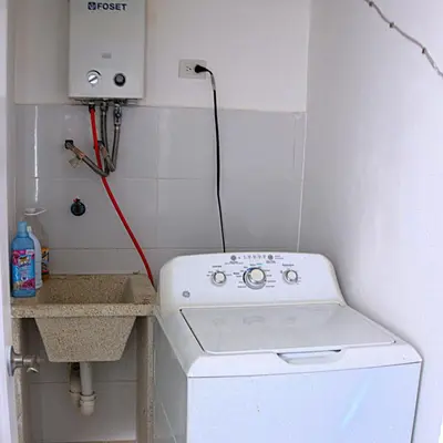 a white washer and dryer in a small bathroom at Residencial selene V, Family Modern Apartment w Pool & Near the beach in Punta Cana