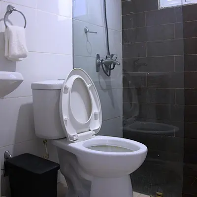 a bathroom with a toilet with the seat up and a shower at Residencial selene V, Family Modern Apartment w Pool & Near the beach in Punta Cana