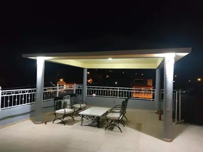 a table and chairs on a balcony at night at Apartamentos ipap luperon in Puerto de Luperon