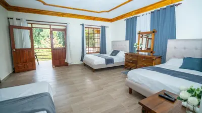 a bedroom with two beds and a wooden floor at Peace By The River in Jarabacoa