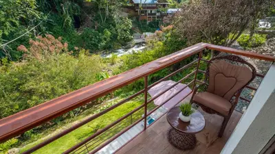a balcony with a table and a chair at Peace By The River in Jarabacoa