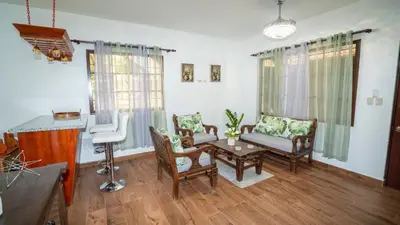 a living room with chairs and a table at Peace By The River in Jarabacoa