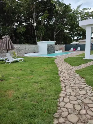 a stone walkway leading to a yard with a pool at Casa merengue in Las Terrenas