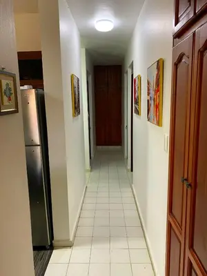 a hallway with a refrigerator and a white tile floor at Casa Corona Plaza in Santiago de los Caballeros