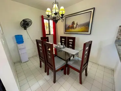 a dining room with a table and chairs and a fan at Casa Corona Plaza in Santiago de los Caballeros