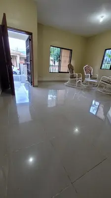 a living room with a white tile floor and chairs at Jarabacoa Mountain Views in Jarabacoa
