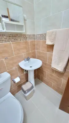 a bathroom with a white sink and a toilet at Jarabacoa Mountain Views in Jarabacoa