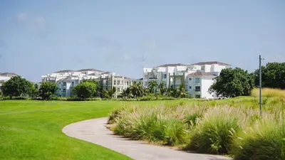 a golf course with a path and buildings in the background at Hard Rock Golf Cozy 1BR • Pool & Golf Views in Punta Cana