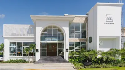 a white building with a front door and stairs at Hard Rock Golf Cozy 1BR • Pool & Golf Views in Punta Cana