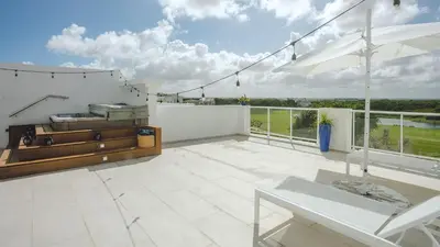 a patio with a white fence and a table at Hard Rock Area PH • Private Jacuzzi + Beach Views in Punta Cana