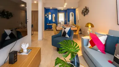 a living room with a blue couch and a table at Luxury Condo with Golf Cart Included in Cana Pearl in Punta Cana