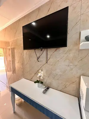a tv hanging on a stone wall with a table at Noè Hotel 1 Bedroom #6 in Punta Cana