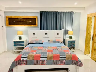 a bedroom with a bed with two night stands and two lamps at Noè Hotel 1 king bedroom # 10 in Punta Cana