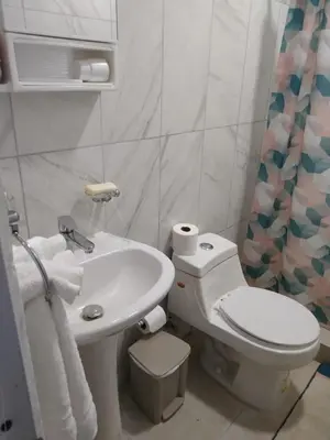a white bathroom with a toilet and a sink at 4 Bedroom 4 Bath & Laundry Room Apartment in Sosúa