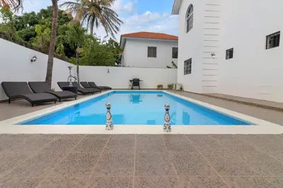 a swimming pool in the backyard of a house at Spacious 3BR APMT- smart speakers Airport transfer in Sosúa
