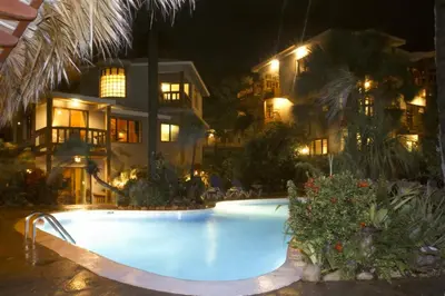 a swimming pool in front of a house at night at El Magnifico in Cabarete