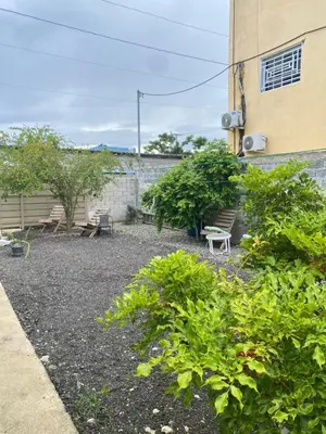 a garden with plants and a bench in front of a building at Luxury Apartment By Merengue House in Boca Chica