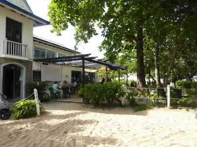 a patio in front of a building with trees at CortLang Vacation Rentals, El Pueblito in San Felipe de Puerto Plata