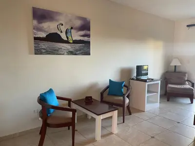 a living room with chairs and a table and a computer at Agualina Kite Hotel Oceanfront Apartments in Cabarete
