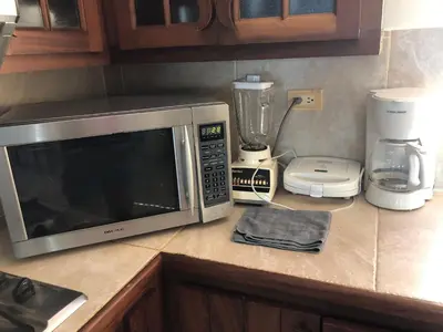 a kitchen counter with a microwave and a blender at Agualina Kite Hotel Oceanfront Apartments in Cabarete