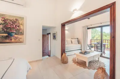 a bedroom with a bed and a table in a room at Fun in the sun classic villa at Los Lagos in Casa de Campo in Cajuiles
