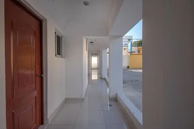 an empty hallway with a red door in a white building at Cozy Double Room in Santo Domingo Este in La Viva