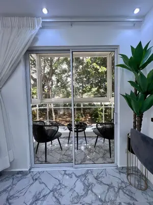 a room with a large window with chairs and a table at Acogedor apartamento 2 hab Distrito nacional, próximo agora mall in Santo Domingo
