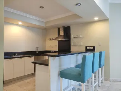 a kitchen with blue chairs at a counter at Chic Beachfront Apartment - Private Beach Access in Punta Cana