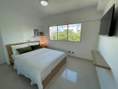 a white bedroom with a bed and a window at Villa Marbella by Potenza Rentals in Santo Domingo