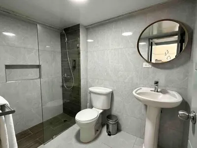 a bathroom with a toilet and a sink and a mirror at Villa Marbella by Potenza Rentals in Santo Domingo