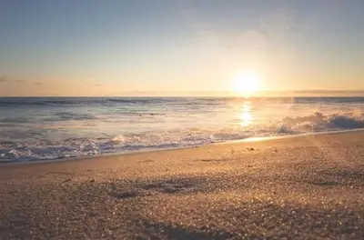 a sunset on a beach with the ocean at Lugar encantador en el Malecón Paraíso, Barahona. in Paraíso