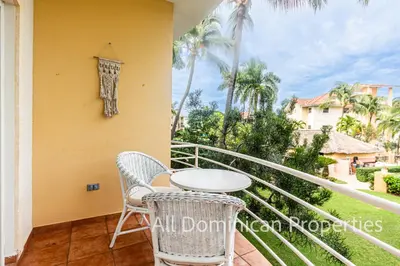 a balcony with a table and chairs and palm trees at Ocean Dream 8205, 2Min to Beach! Apt Kite Paradise! in Cabarete
