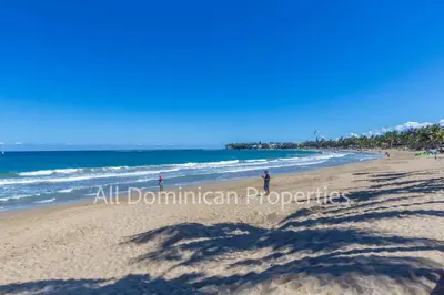 a group of people walking on the beach at Ocean Dream 8205, 2Min to Beach! Apt Kite Paradise! in Cabarete